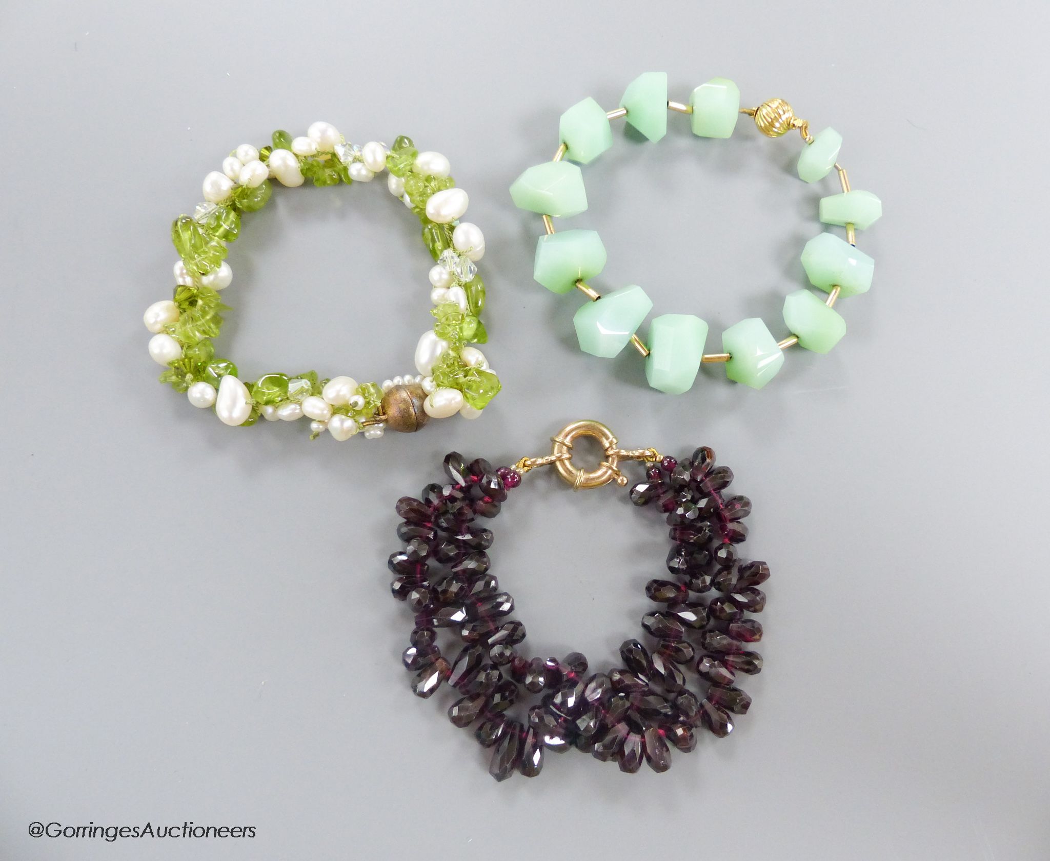 A modern shaped facetted garnet bead twin strand bracelet, with 375 clasp, approx. 19cm, gross 49.2 grams, a similar peridot and baroque pearl bracelet, with gilt 925 clasp and a green chalcedony? facet cut bracelet, wit